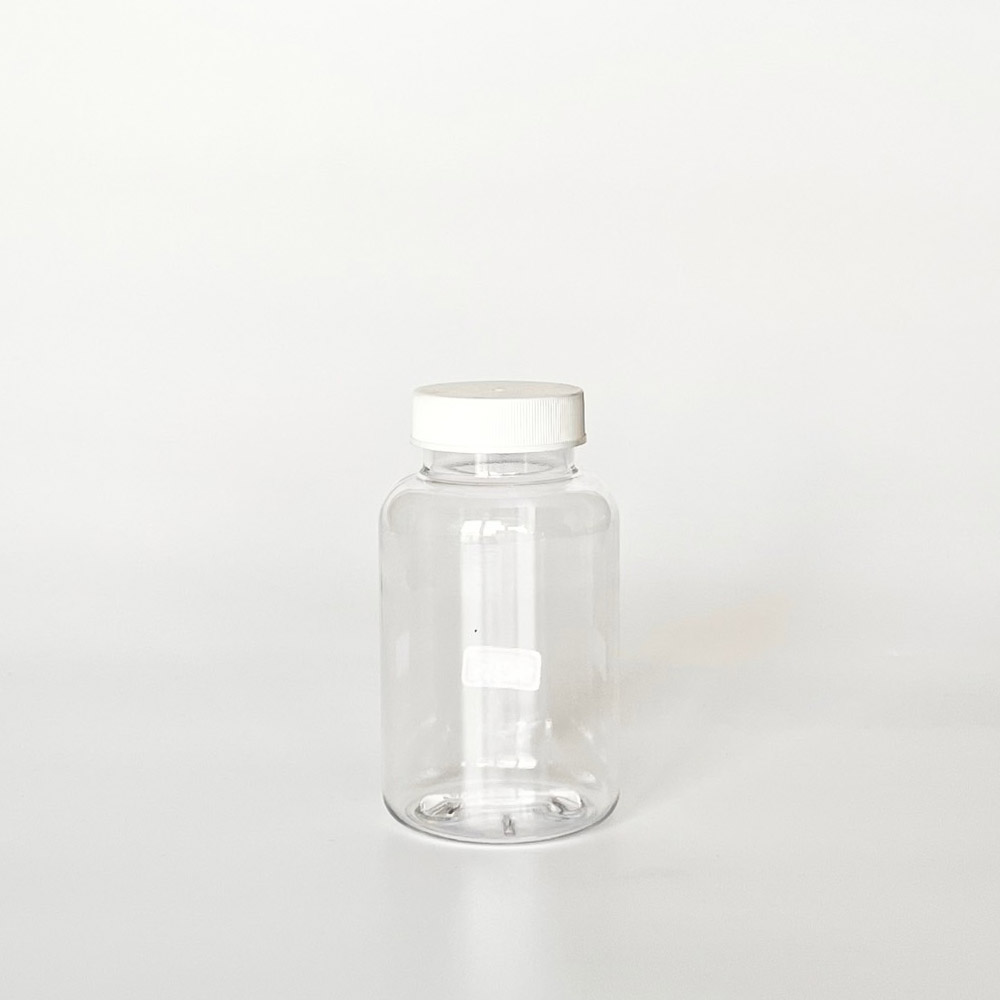 TNPG-175，透明一般蓋175ml PETG錠劑瓶，是由透明的PETG塑膠瓶上面搭配38mm的白色普通瓶蓋，一般瓶蓋裡面含有感壓封口紙，整組瓶子直立於一張白色背景上。此塑膠容器通常用於保健食品、醫療藥品、健康食品、分裝藥瓶、藥罐或是寵物用藥品身上。