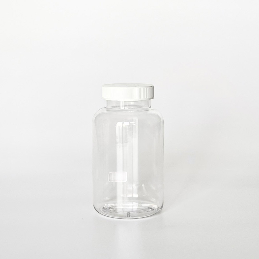 TNPG-275，透明一般蓋275ml PETG錠劑瓶，是由透明的PETG塑膠瓶上面搭配45mm的白色普通瓶蓋，一般瓶蓋裡面含有感壓封口紙，整組瓶子直立於一張白色背景上。此塑膠容器通常用於保健食品、醫療藥品、健康食品、分裝藥瓶、藥罐或是寵物用藥品身上。