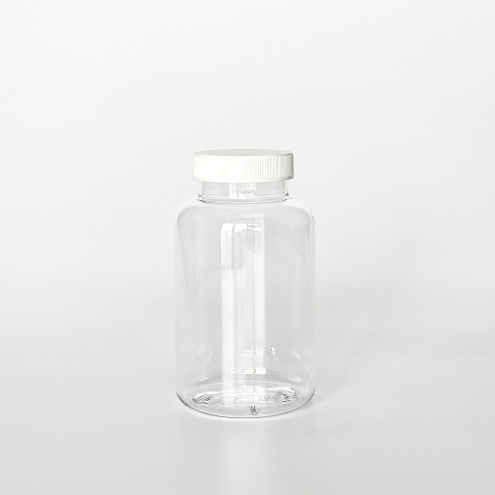 TNPG-300，透明一般蓋300ml PETG錠劑瓶，是由透明的PETG塑膠瓶上面搭配45mm的白色普通瓶蓋，一般瓶蓋裡面含有感壓封口紙，整組瓶子直立於一張白色背景上。此塑膠容器通常用於保健食品、醫療藥品、健康食品、分裝藥瓶、藥罐或是寵物用藥品身上。